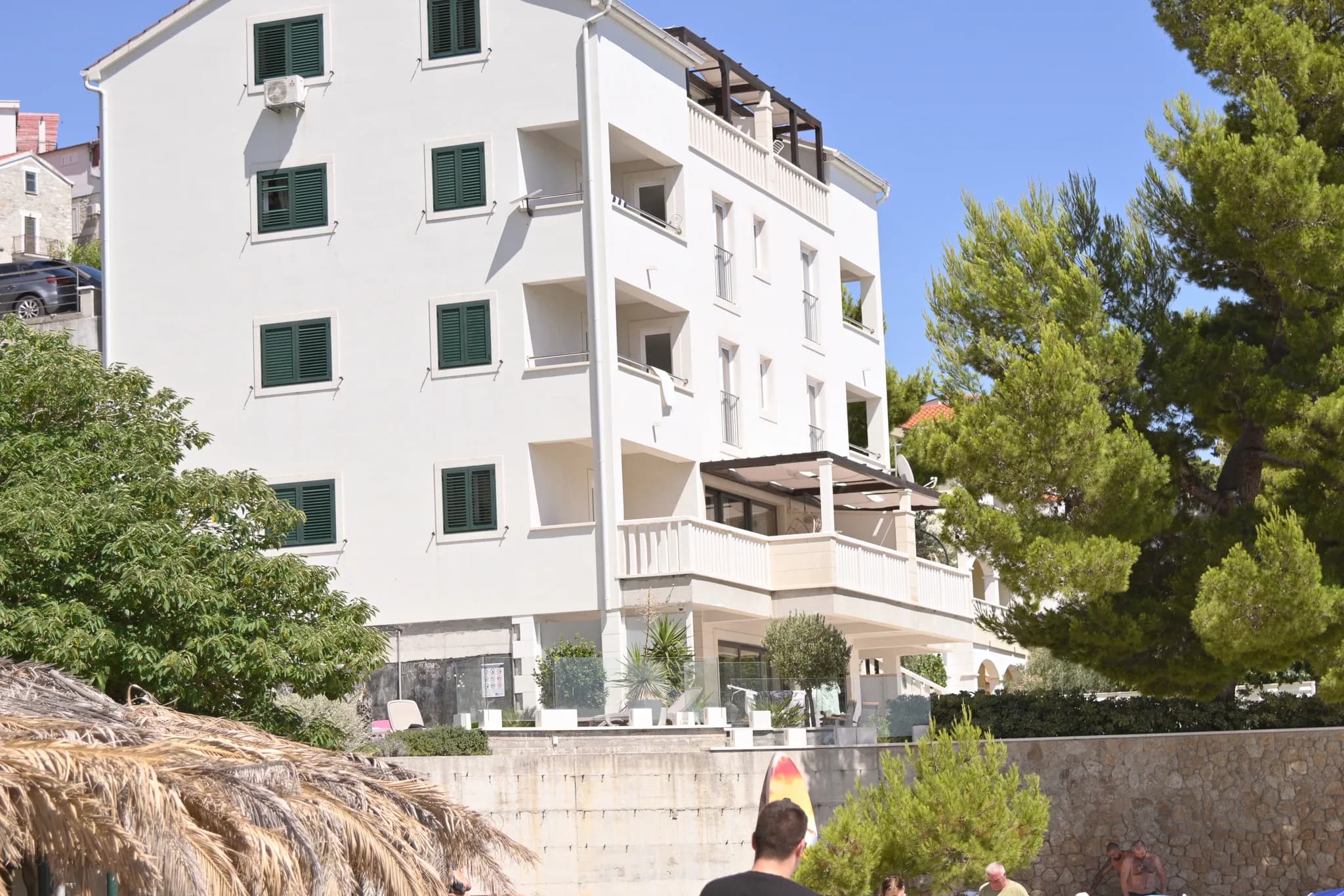Facade of Villa Carica overlooking the beach, with a parasol